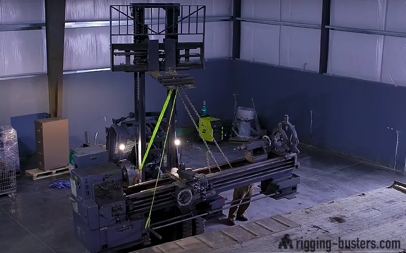 Lathe rigged with lifting slings in a workshop